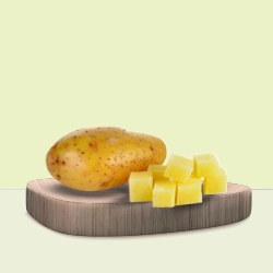 Whole potato with neatly diced yellow potato cubes displayed on a wooden board for cooking inspiration.